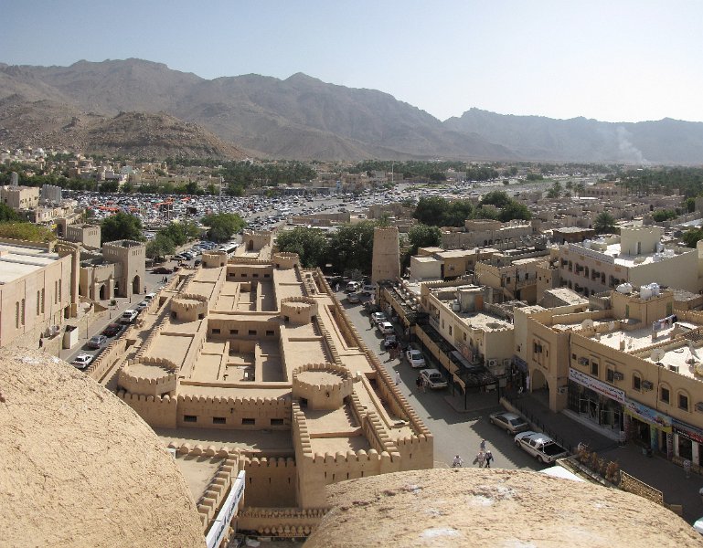 040211_uitzicht over nizwa.jpg - Vrijdag, in de Islamitische wereld de zondag. We bezoeken Nizwa. Khalid, een collega van Robert, zal ons rondleiden op de geitenmarkt.Op de foto, uitzicht over Nizwa vanaf het fort. De wadi word gebruikt als parkeerterrein voor alle handelaren en bezoekers van de markt.